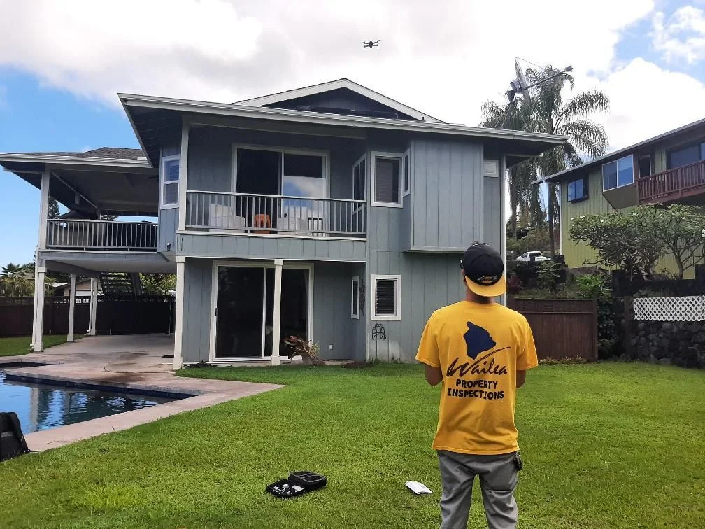Inspector operating a drone above the roof of a home.